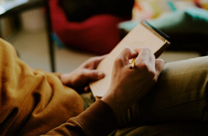 Closeup of hands of unrecognizable creative man doodling in sketchbook